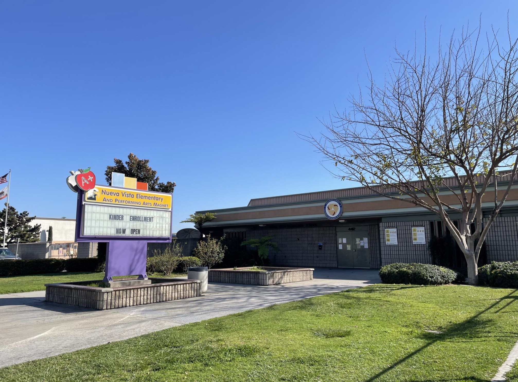 A sign in front of a school building reads "Nueva Vista Elementary and Performing Arts Magnet."